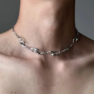 A chunky silver chain necklace worn close around the neck