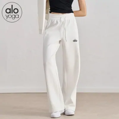 White wide-leg sweatpants worn by a model against a plain wall